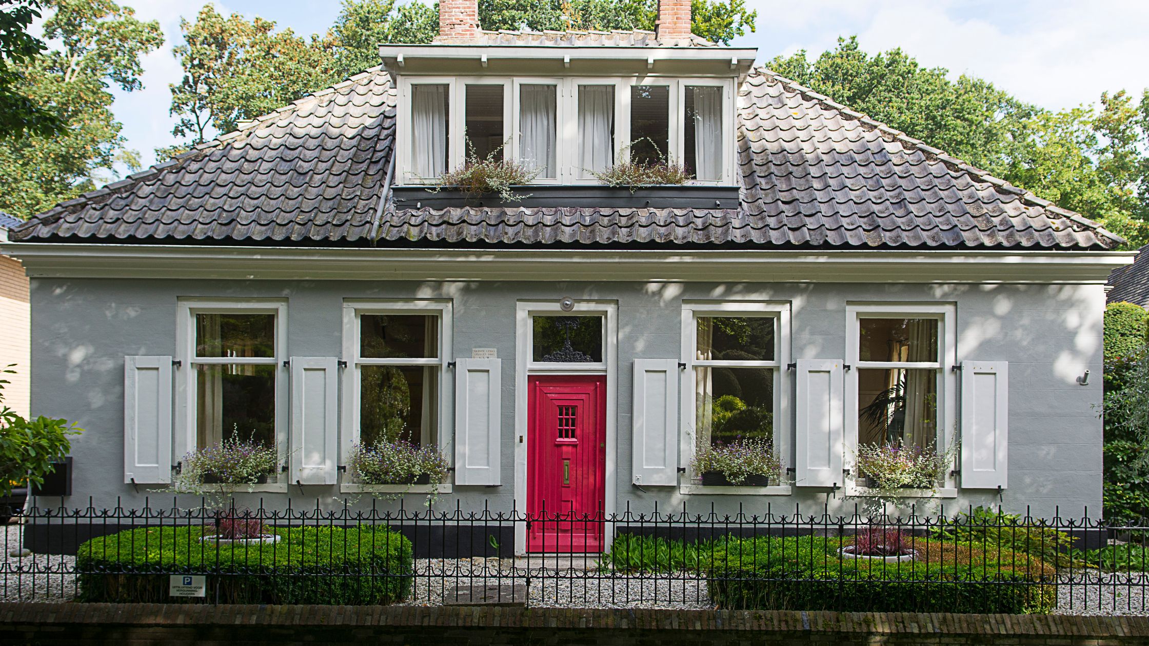Front view of a well-maintained Ontario home with secure windows and a vibrant new entry door, showcasing how to protect your home with new doors.